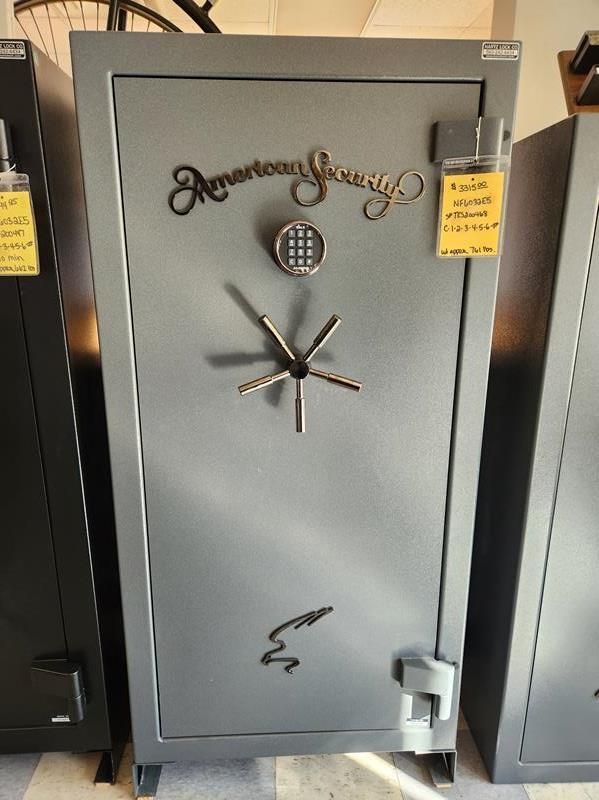 Gray American Security safe with combination lock and handle, in a showroom.