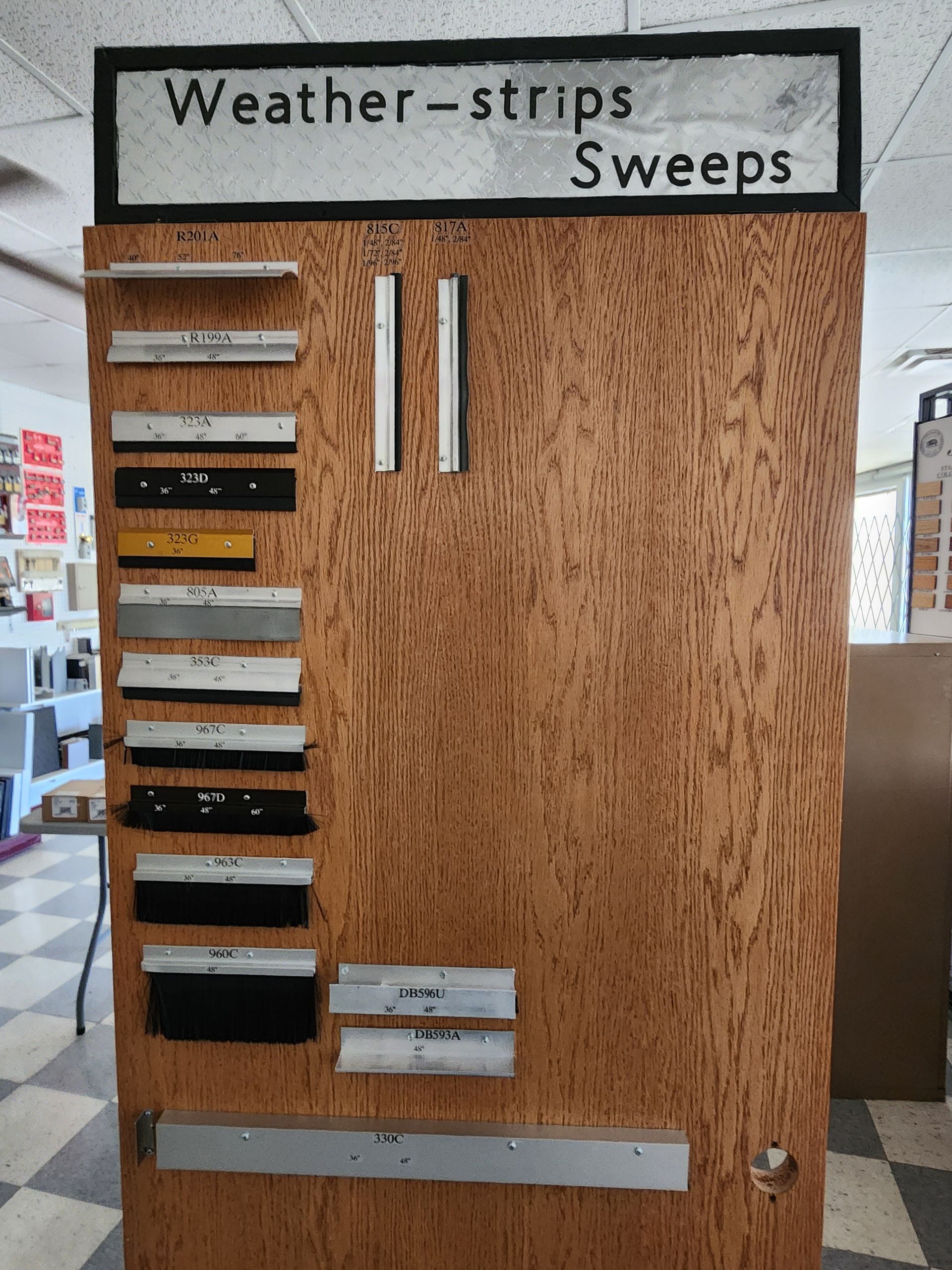Display of weather strips and sweeps on a wooden board, labeled 