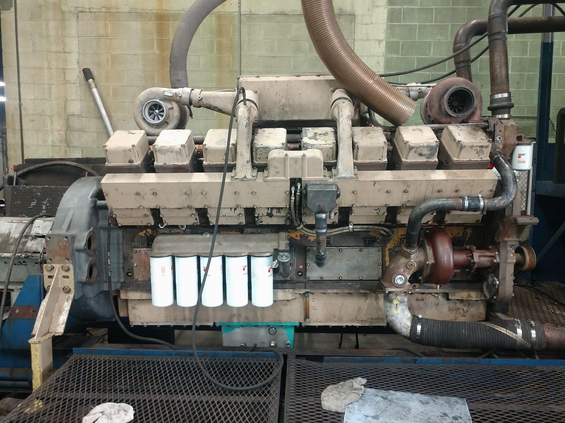 Large industrial diesel engine with multiple cylinders and turbochargers, mounted on a testing platform.