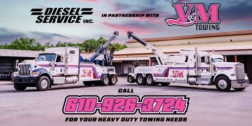 Two heavy-duty white tow trucks parked side-by-side.