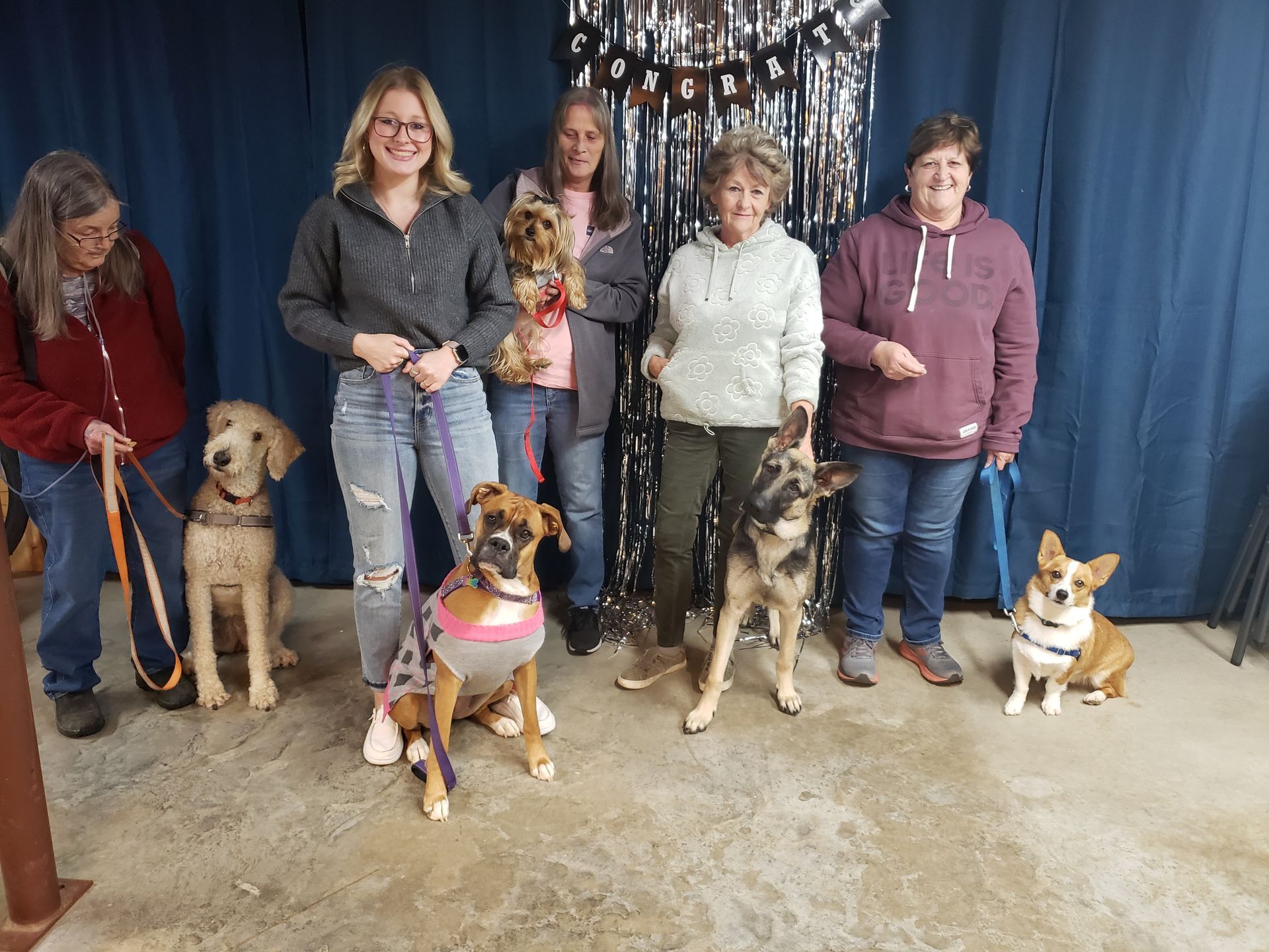 a group of women and their dogs are posing for a picture