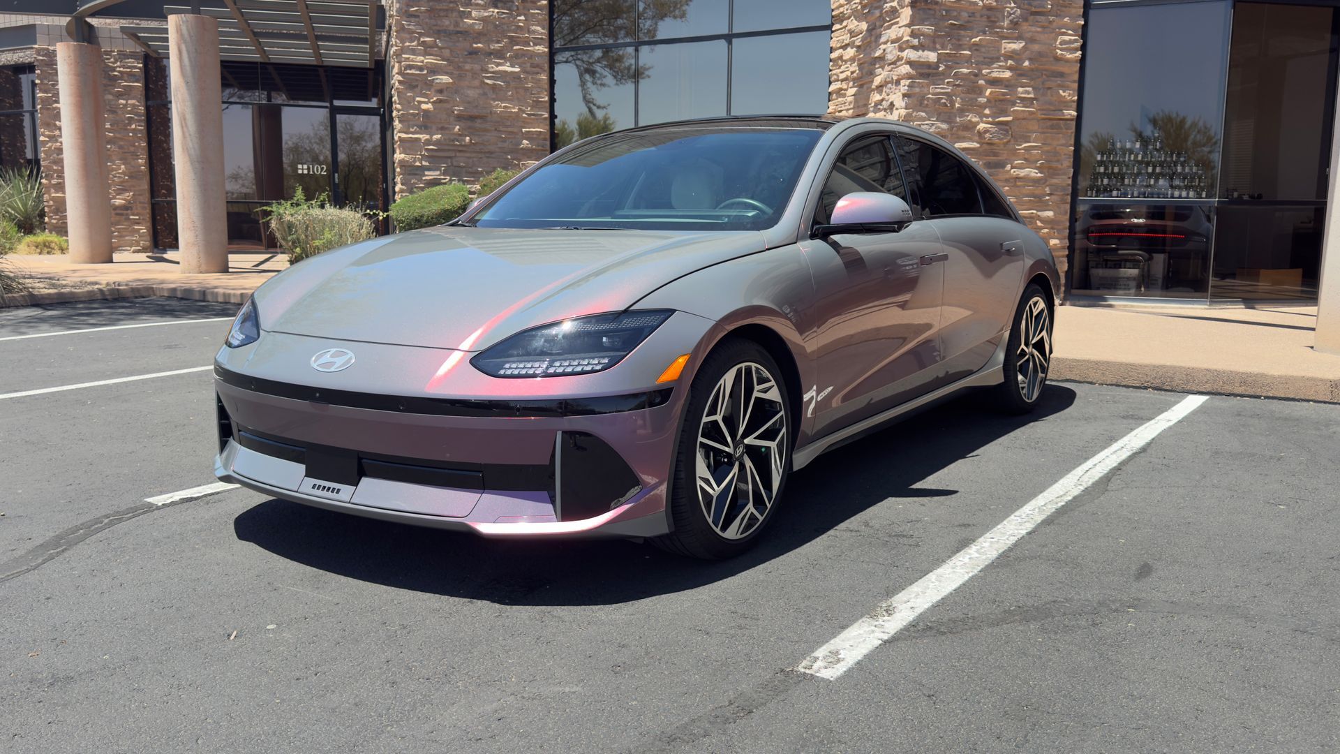 Gray sports sedan parked outside a brick building in a parking lot