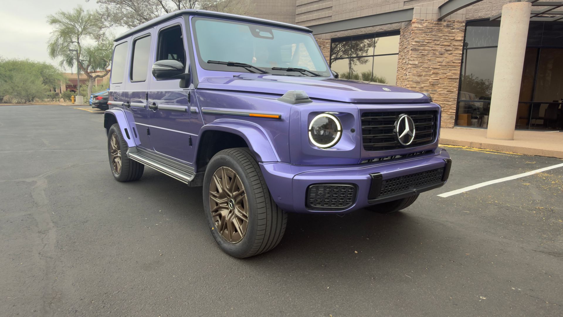 Purple Mercedes-Benz G-Class SUV parked in a lot beside a building