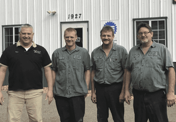 Four men standing in front of a building.
