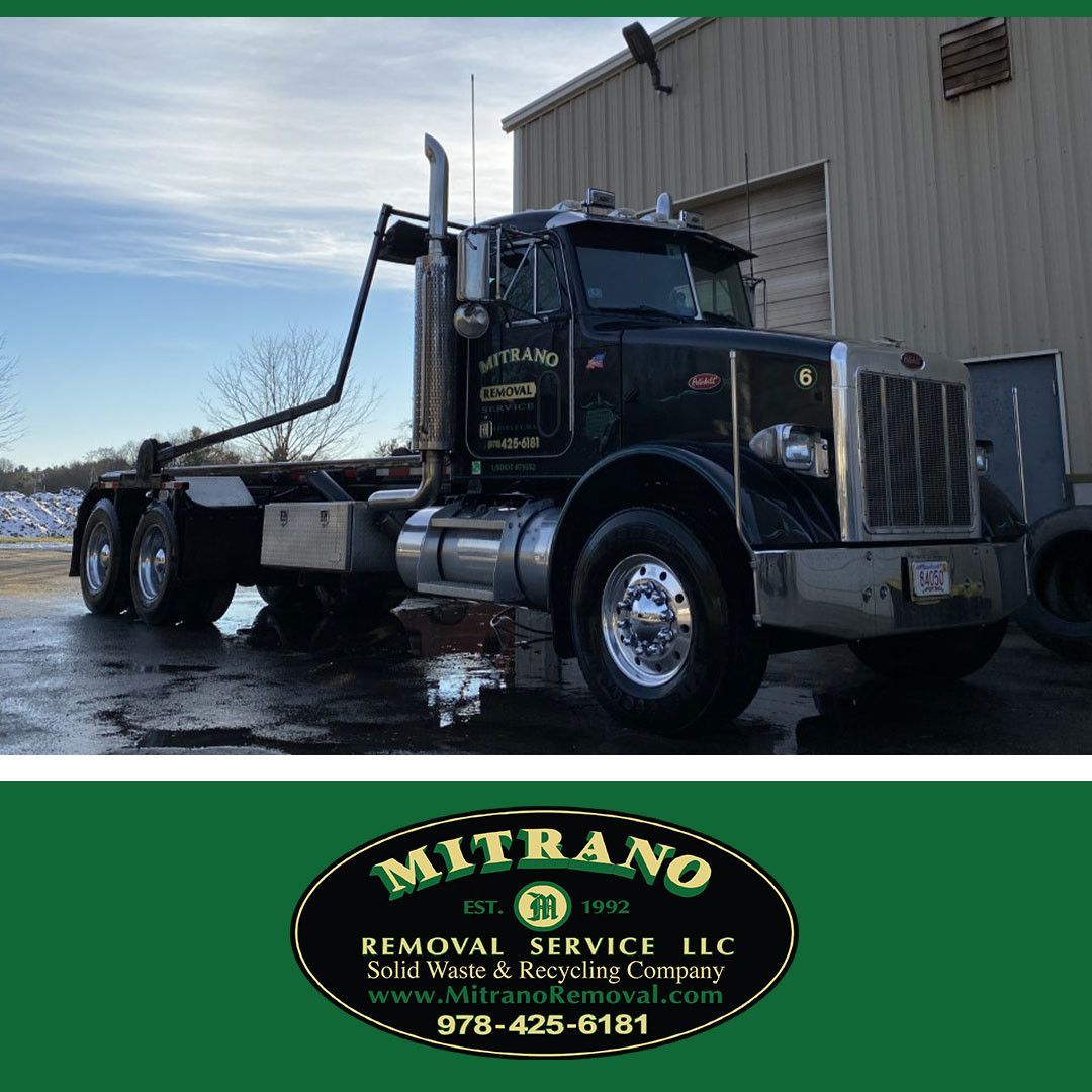 Black Mitrano Removal Service truck parked outside a building.