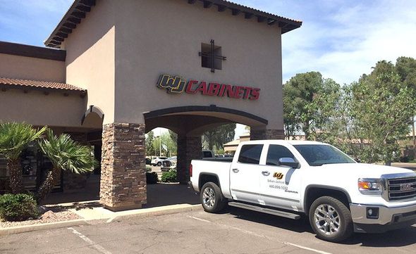 A white truck is parked in front of a building that says carpets