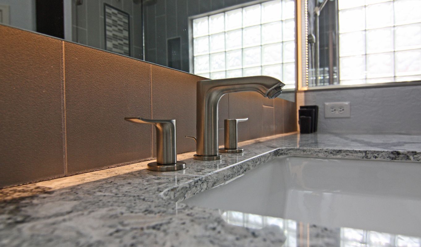 A bathroom sink with a faucet and a mirror.