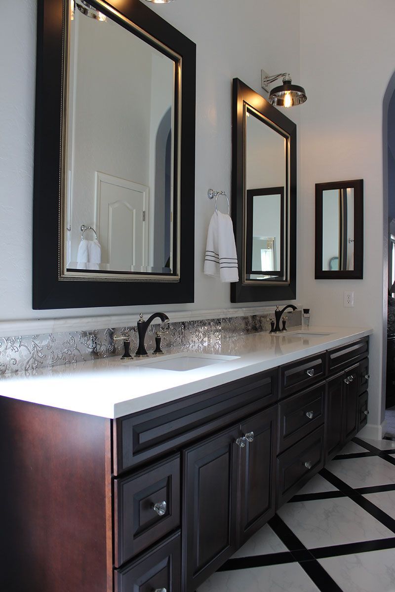 A bathroom with two sinks and two mirrors
