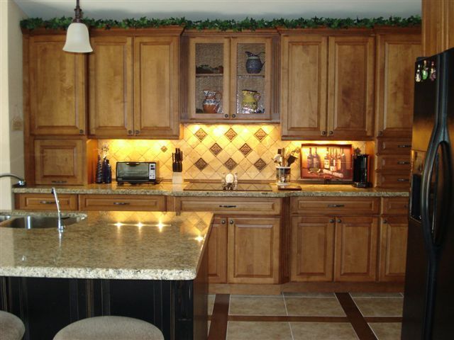 A kitchen with wooden cabinets and granite countertops