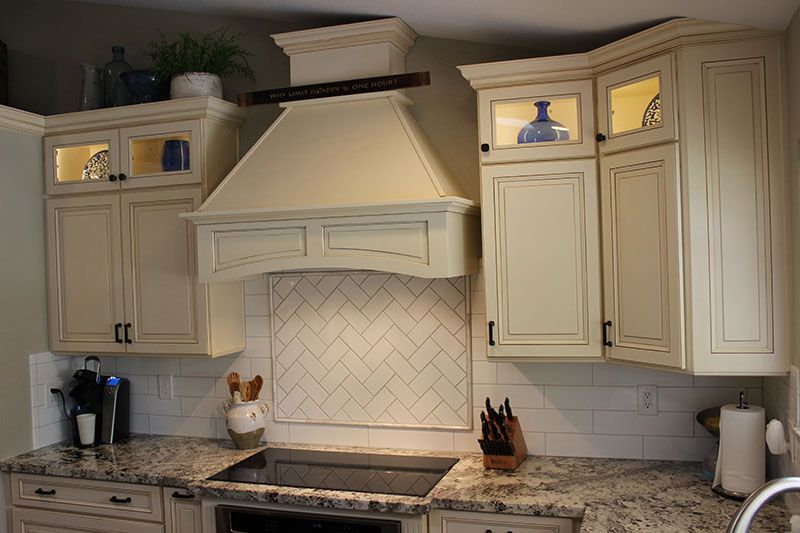 A kitchen with white cabinets and a stove-top oven