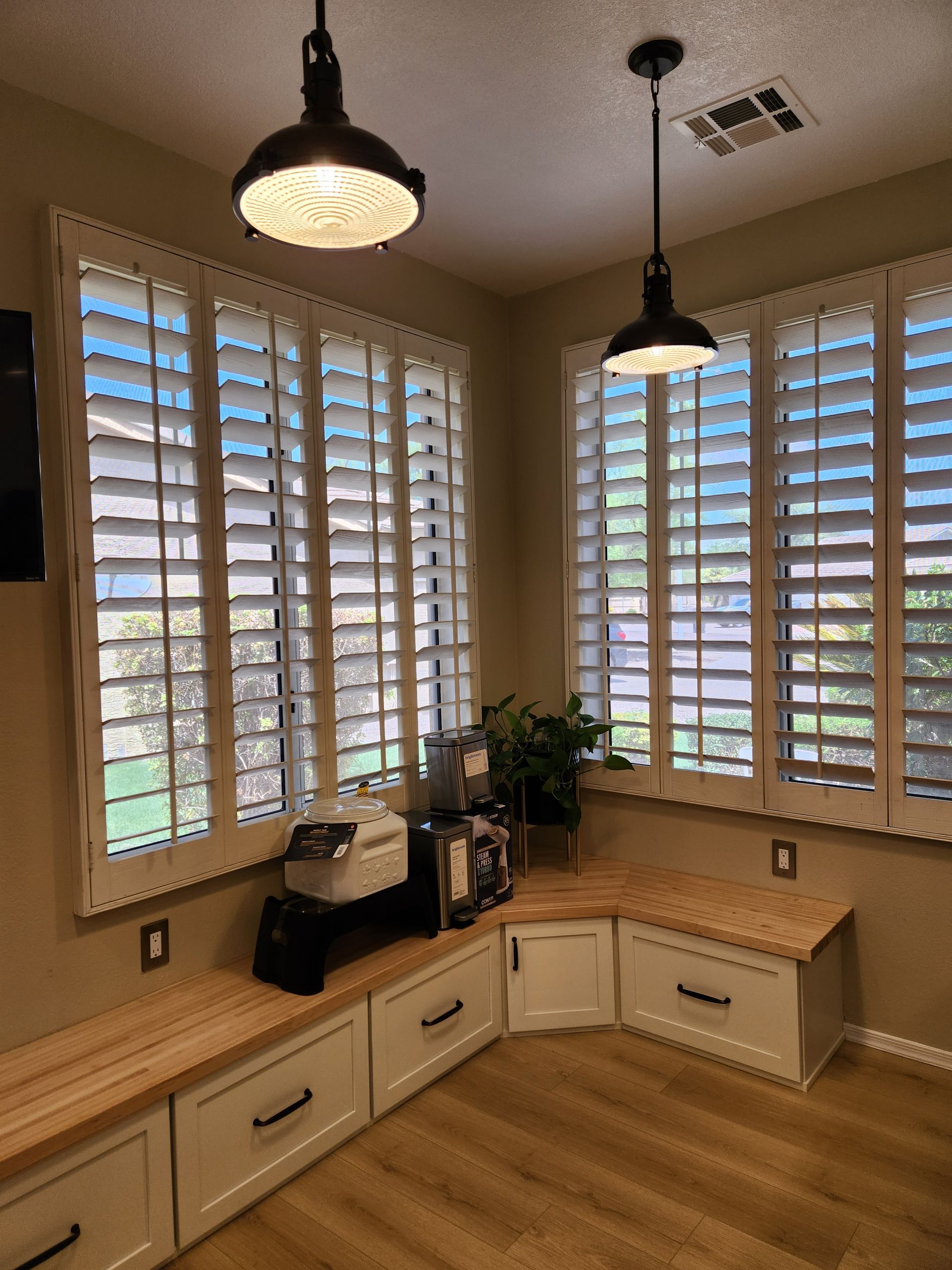 A kitchen with a bench and shutters on the windows