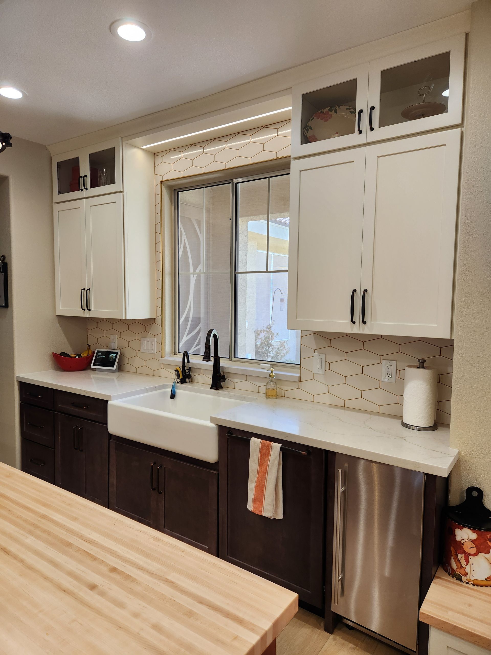 A kitchen with white cabinets, a sink, and a stainless steel dishwasher.
