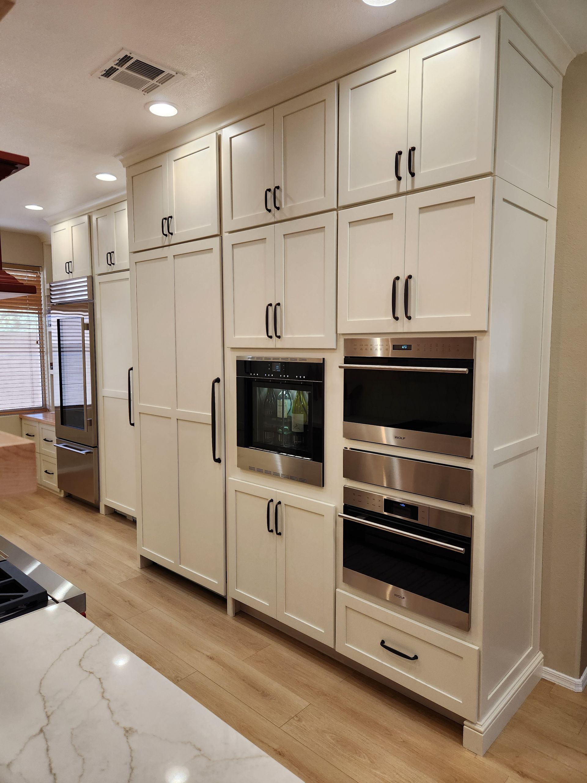 A kitchen with white cabinets and stainless steel appliances