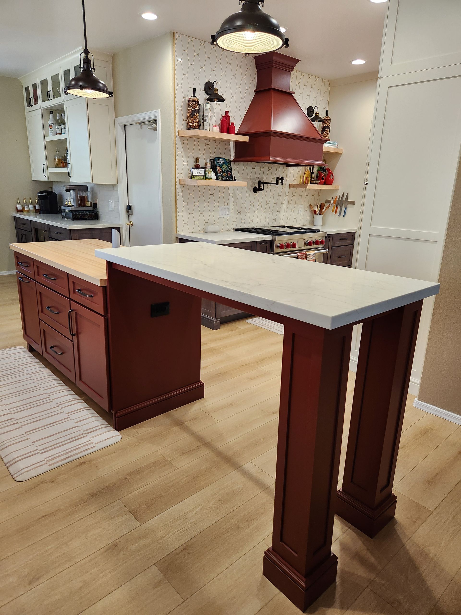 A kitchen with a red island and a white counter top.