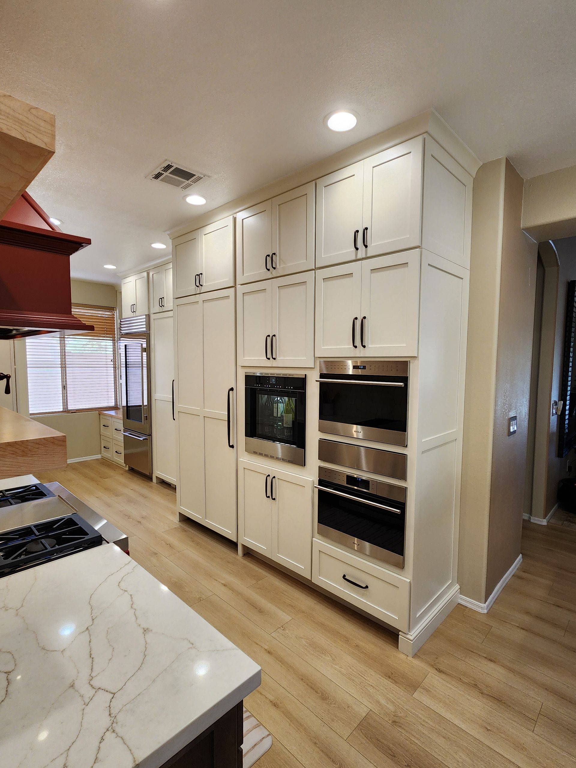 A kitchen with white cabinets and stainless steel appliances.