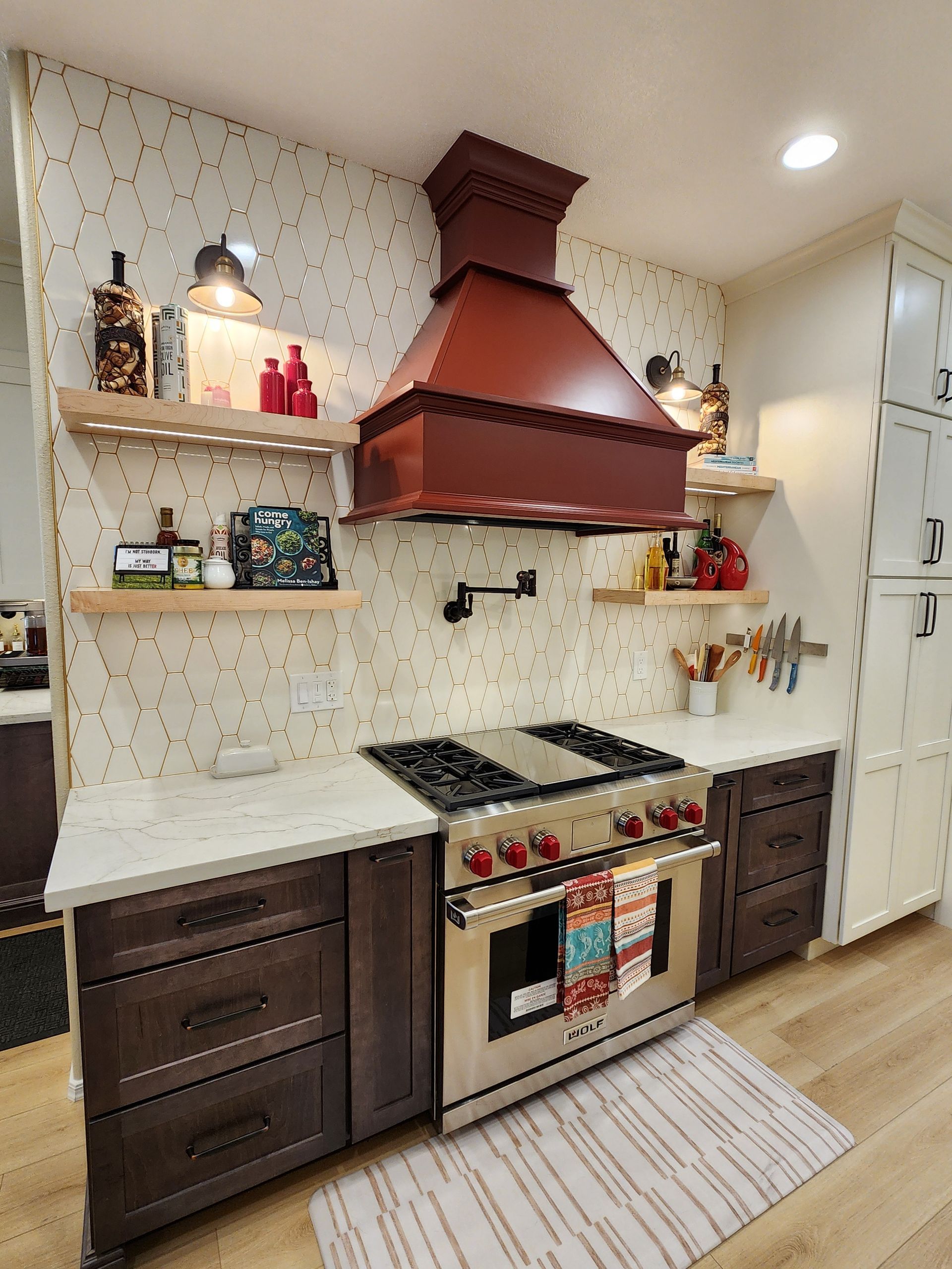 A kitchen with a stove, oven, and hood.