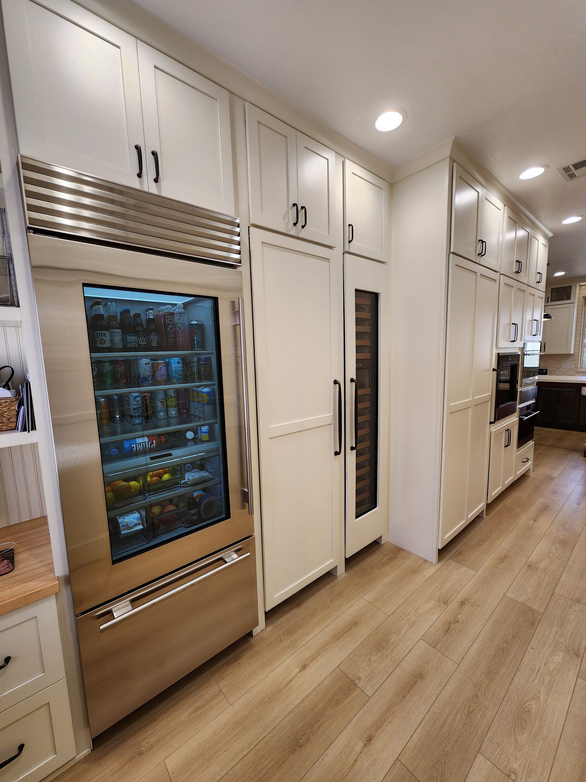 A kitchen with stainless steel appliances and white cabinets.