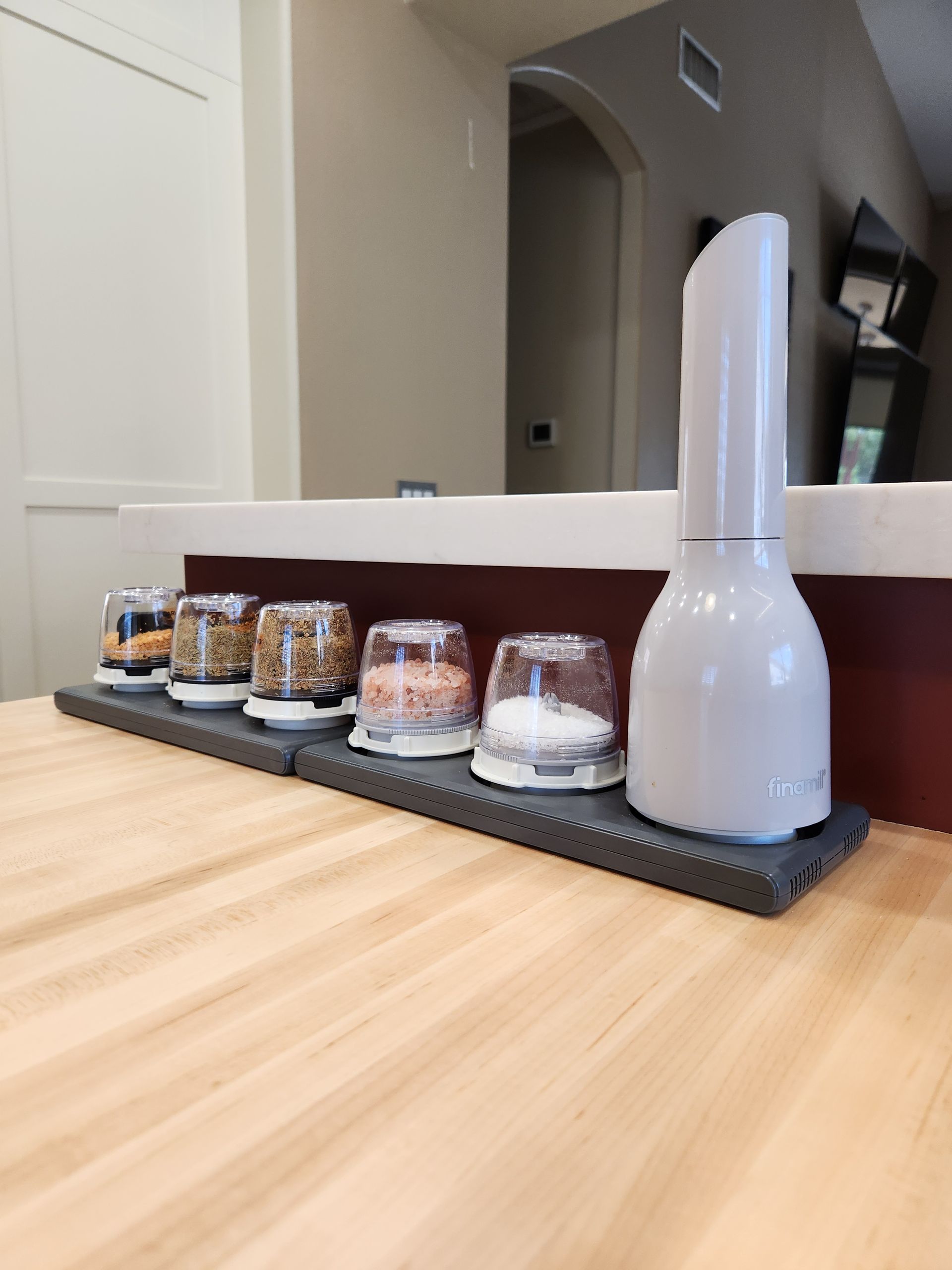 A kitchen counter with a blender and jars on it