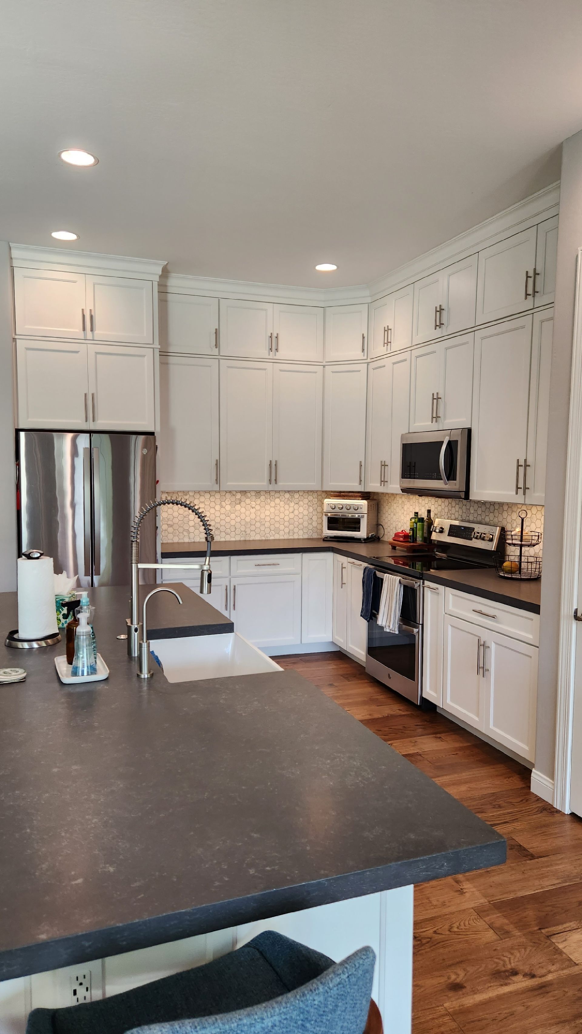 A kitchen with white cabinets and stainless steel appliances.