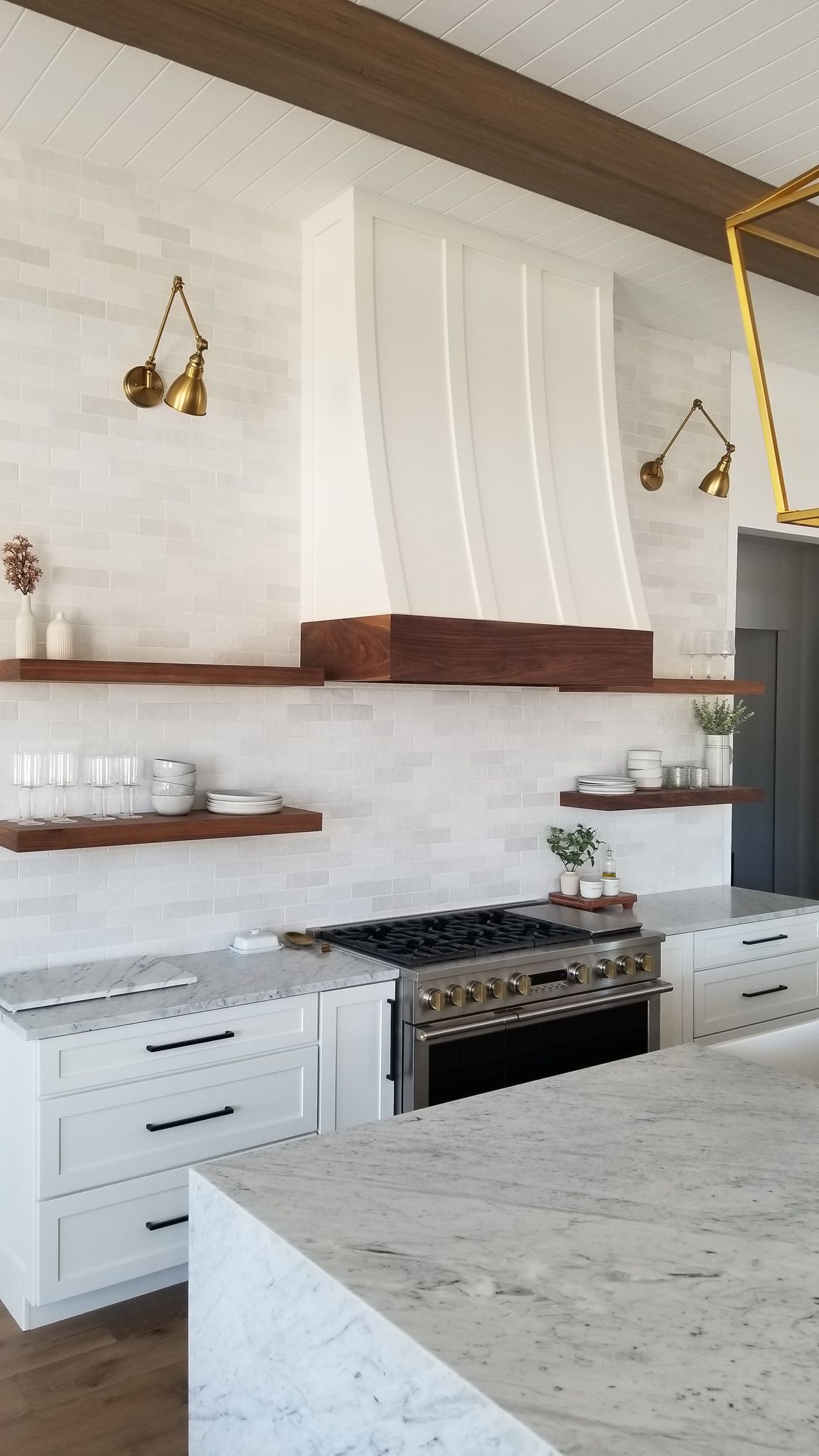 A kitchen with white cabinets, a stove, and a refrigerator.