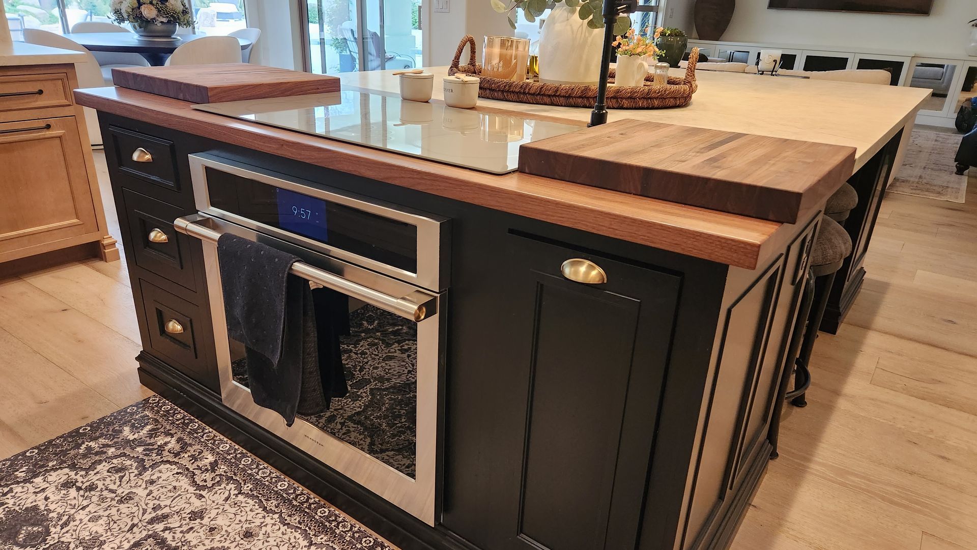 A kitchen island with a stovetop oven and a towel rack.