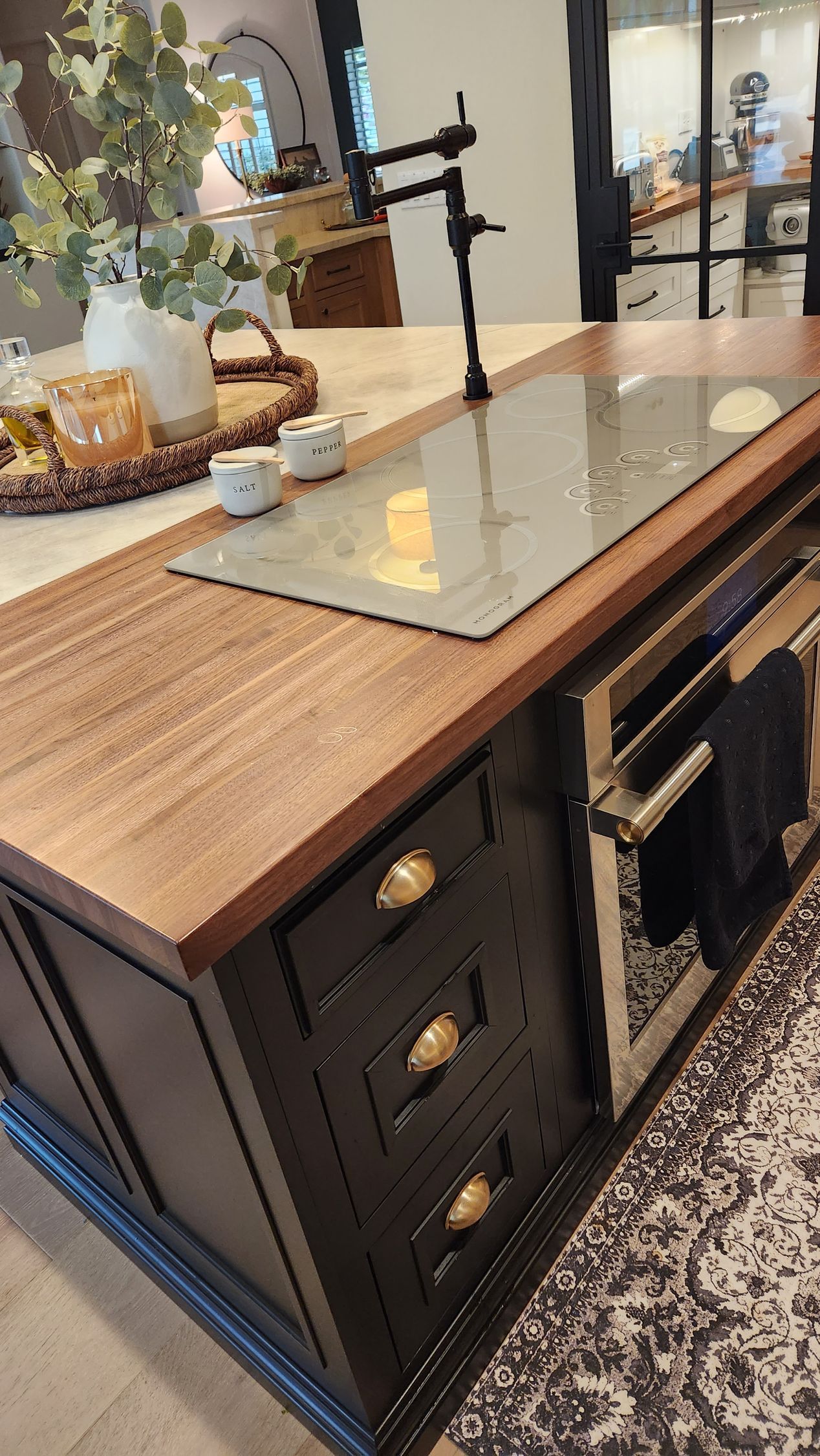 A kitchen island with a stovetop oven and a sink.