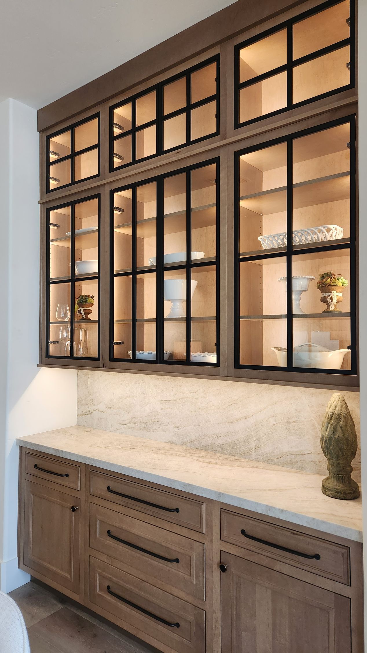 A kitchen with wooden cabinets and glass doors.