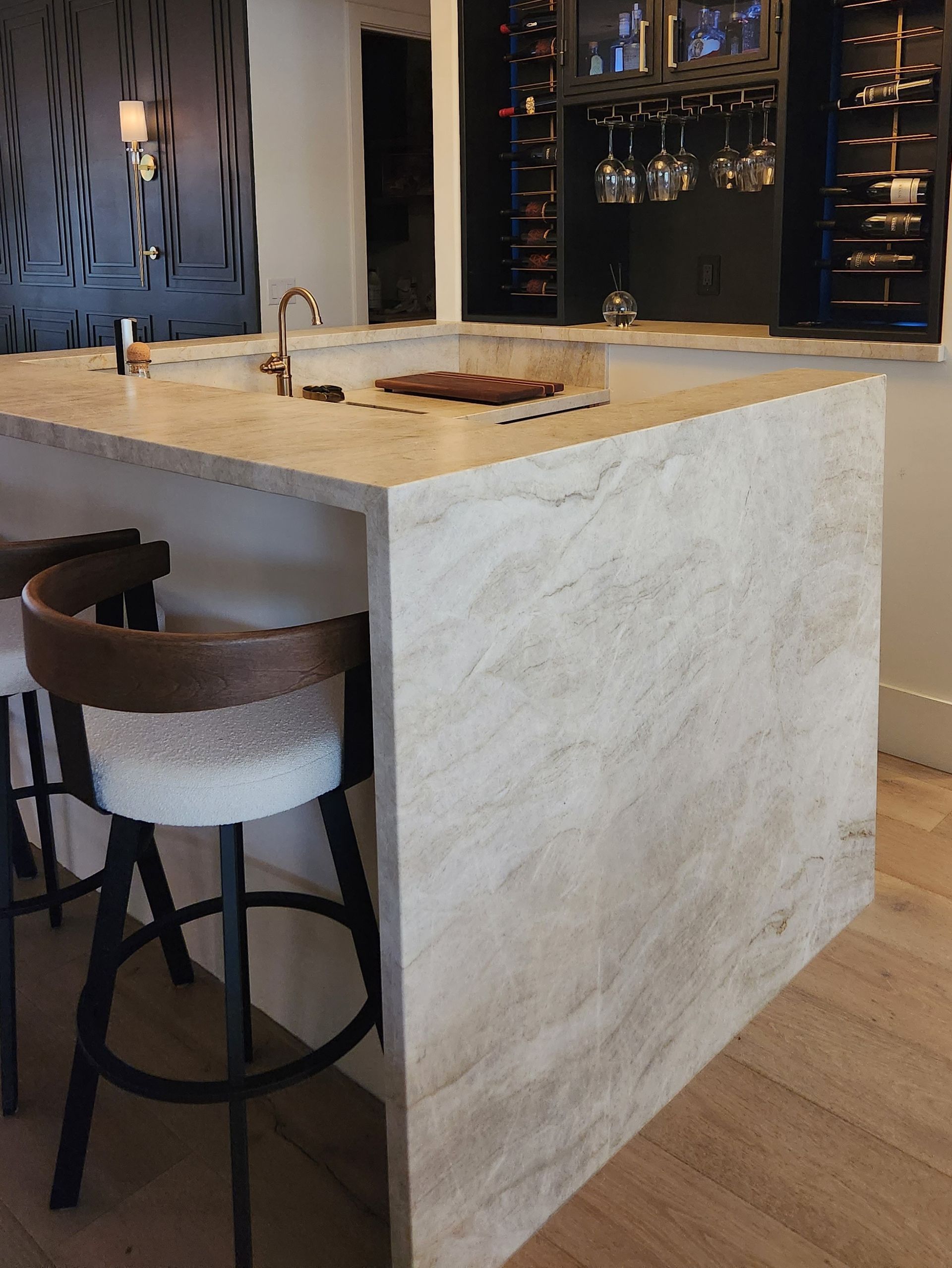 A kitchen with a large island and two bar stools