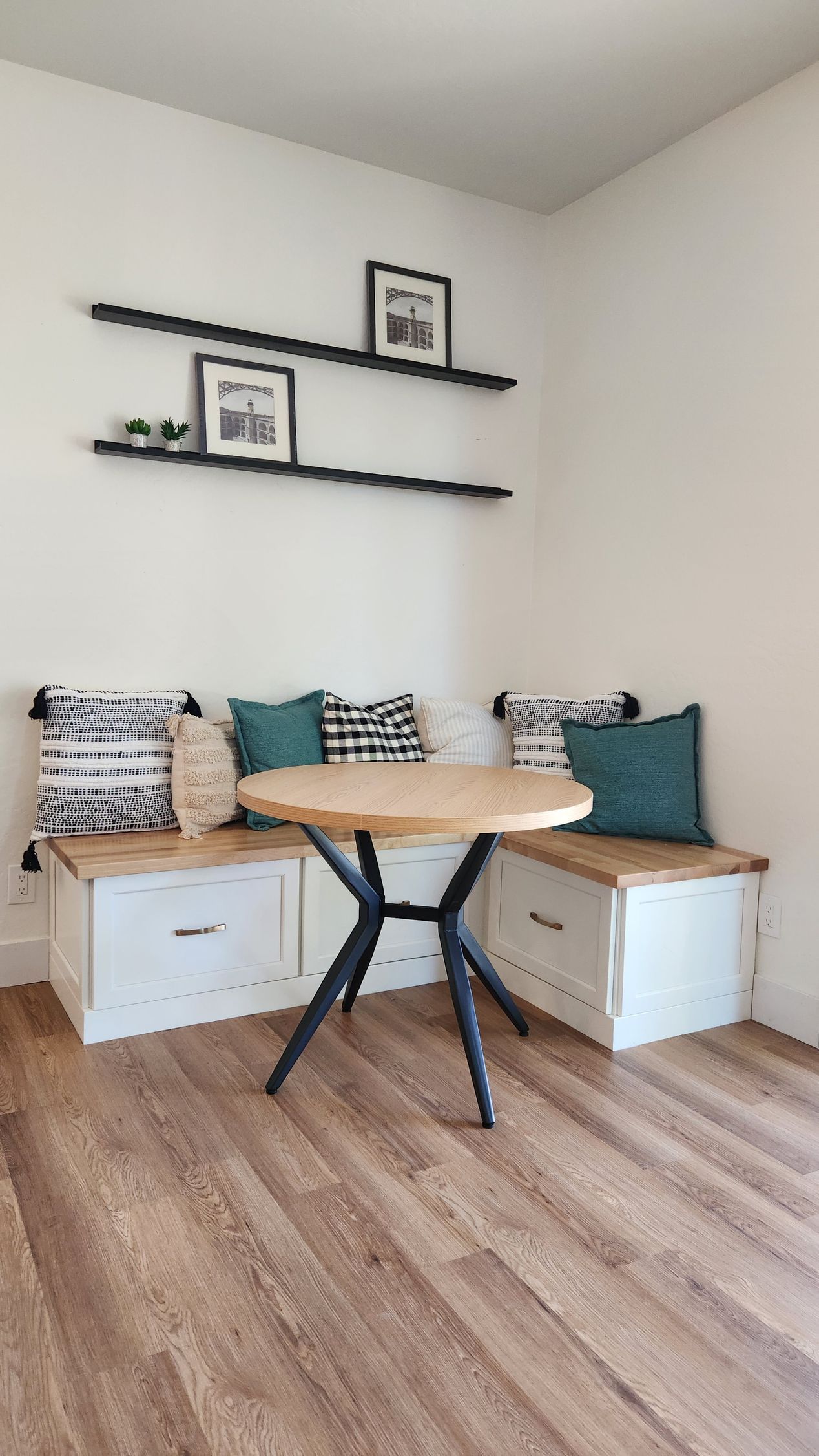 There is a table and a bench in the corner of the room.