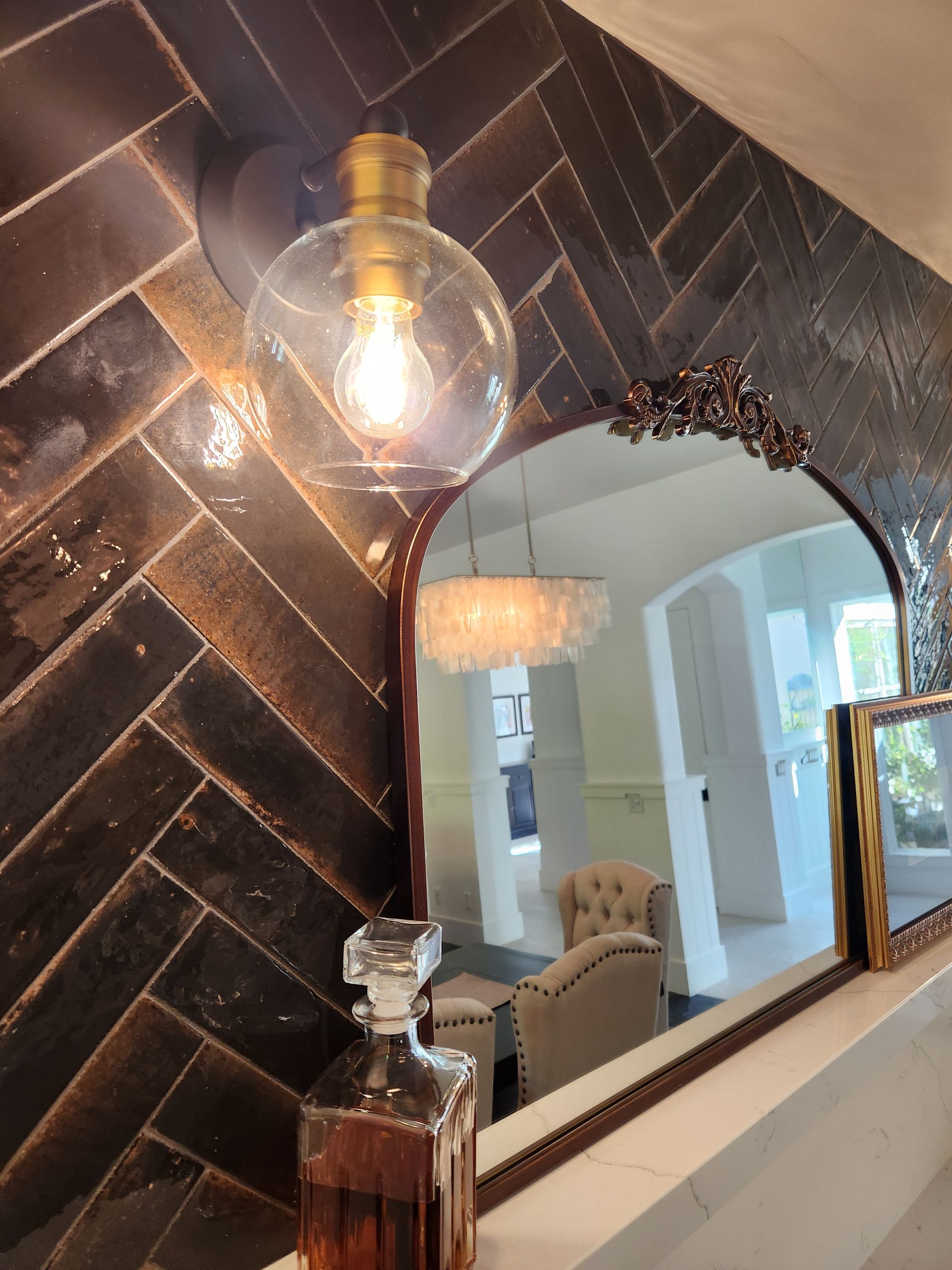 A bottle of alcohol is sitting in front of a mirror.