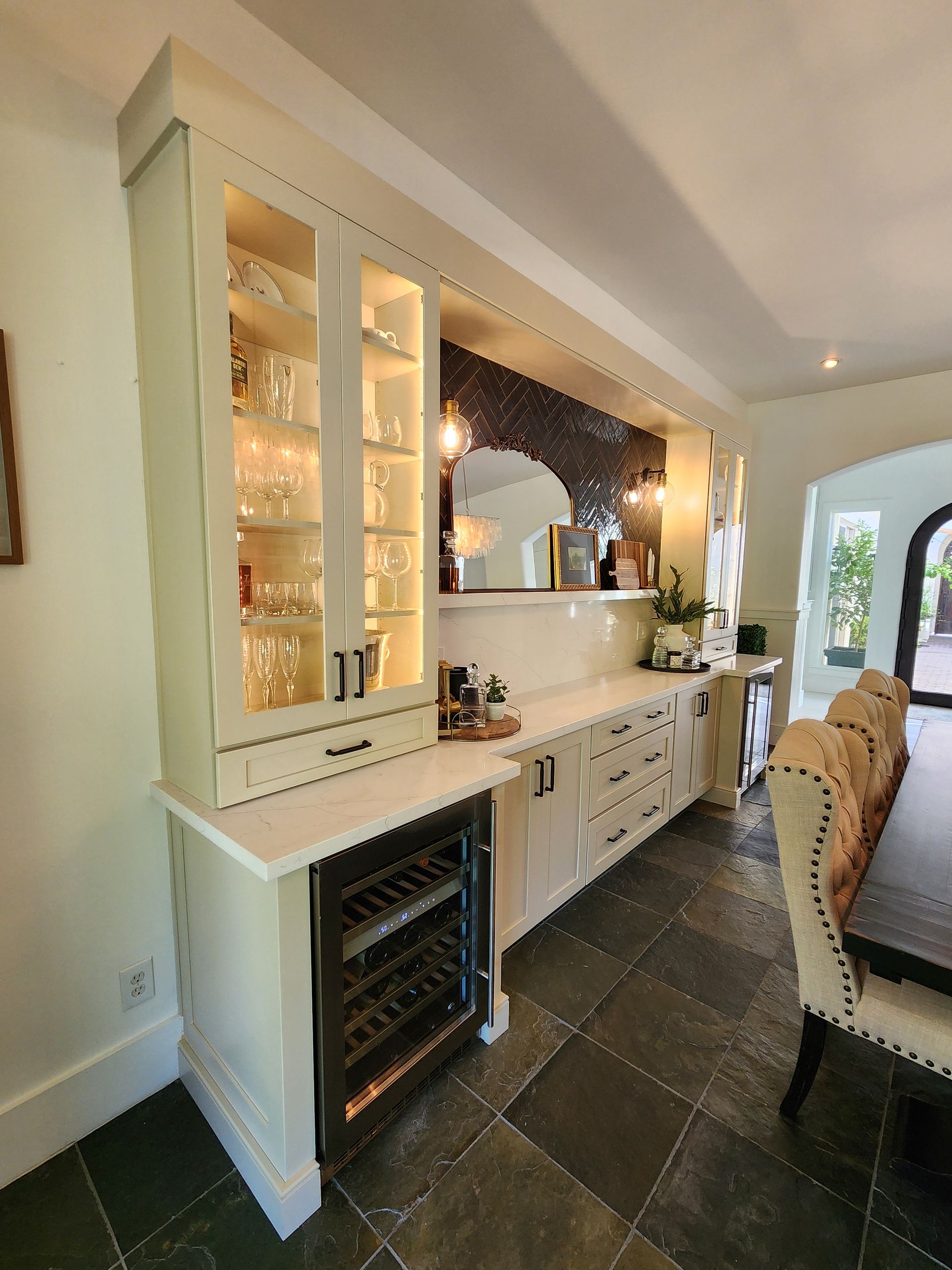 A kitchen with white cabinets and a wine cooler