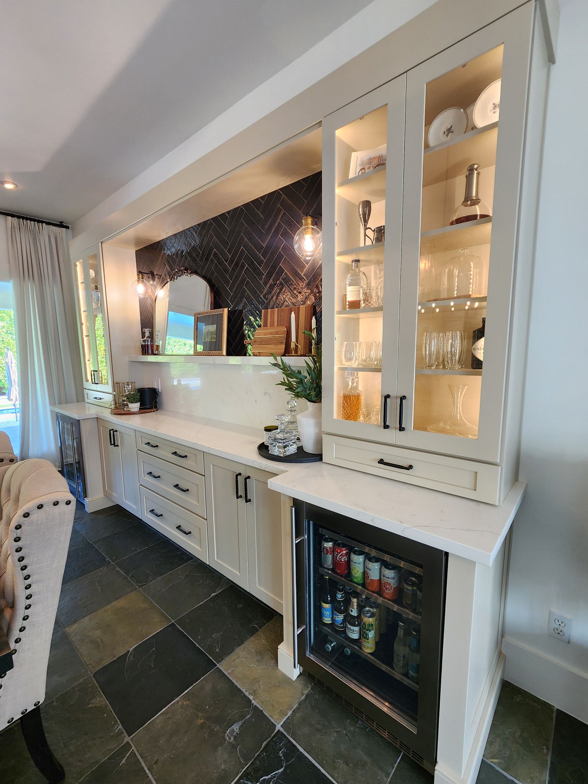 A kitchen with white cabinets and a refrigerator.