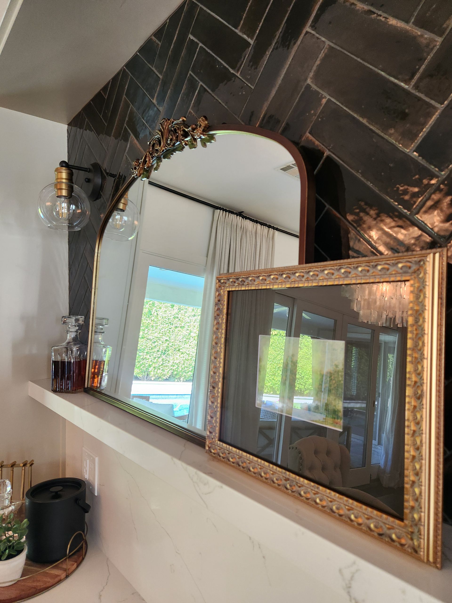 Two mirrors are sitting on a shelf in a room.