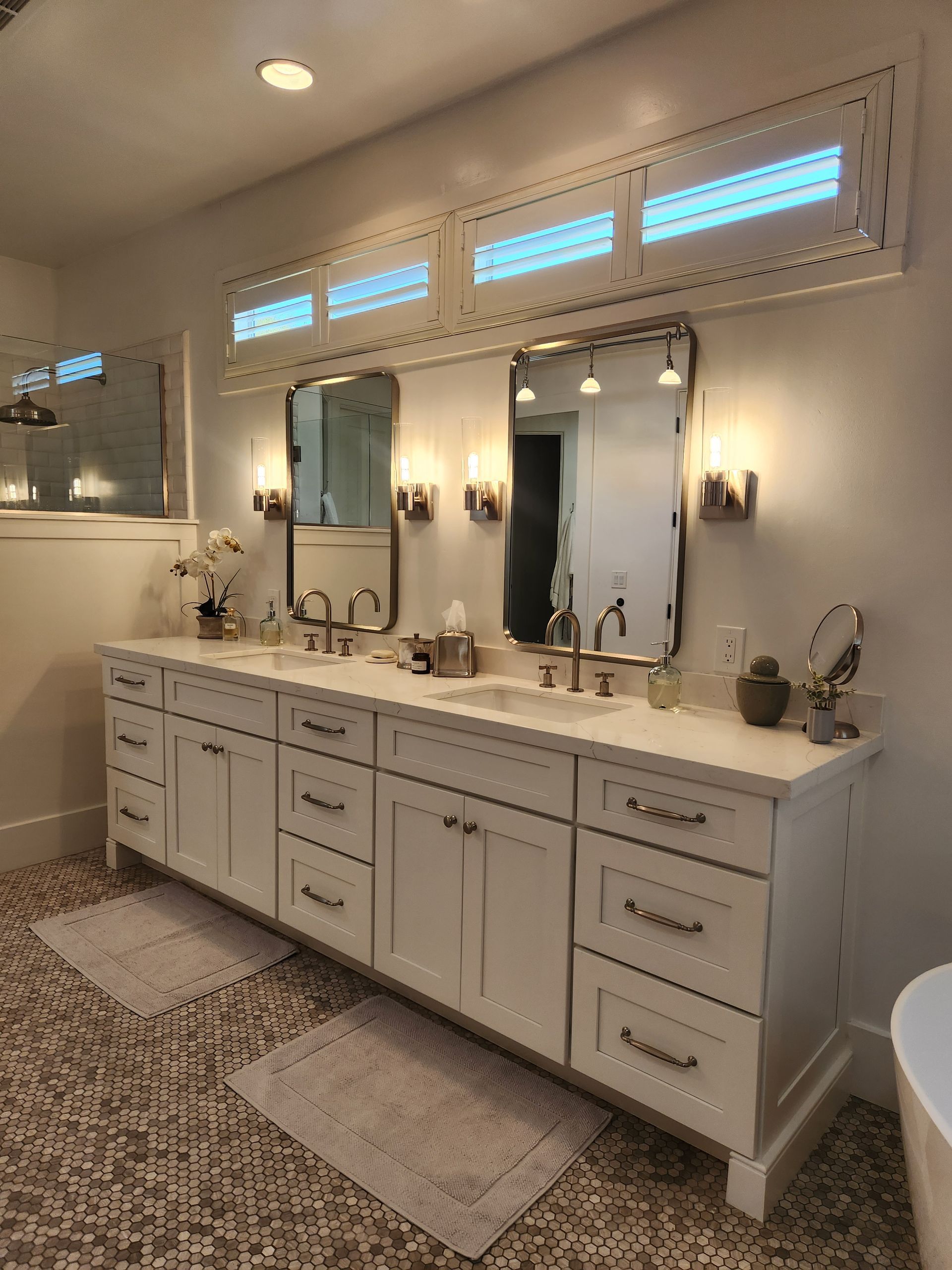 A bathroom with two sinks, two mirrors, and a tub.