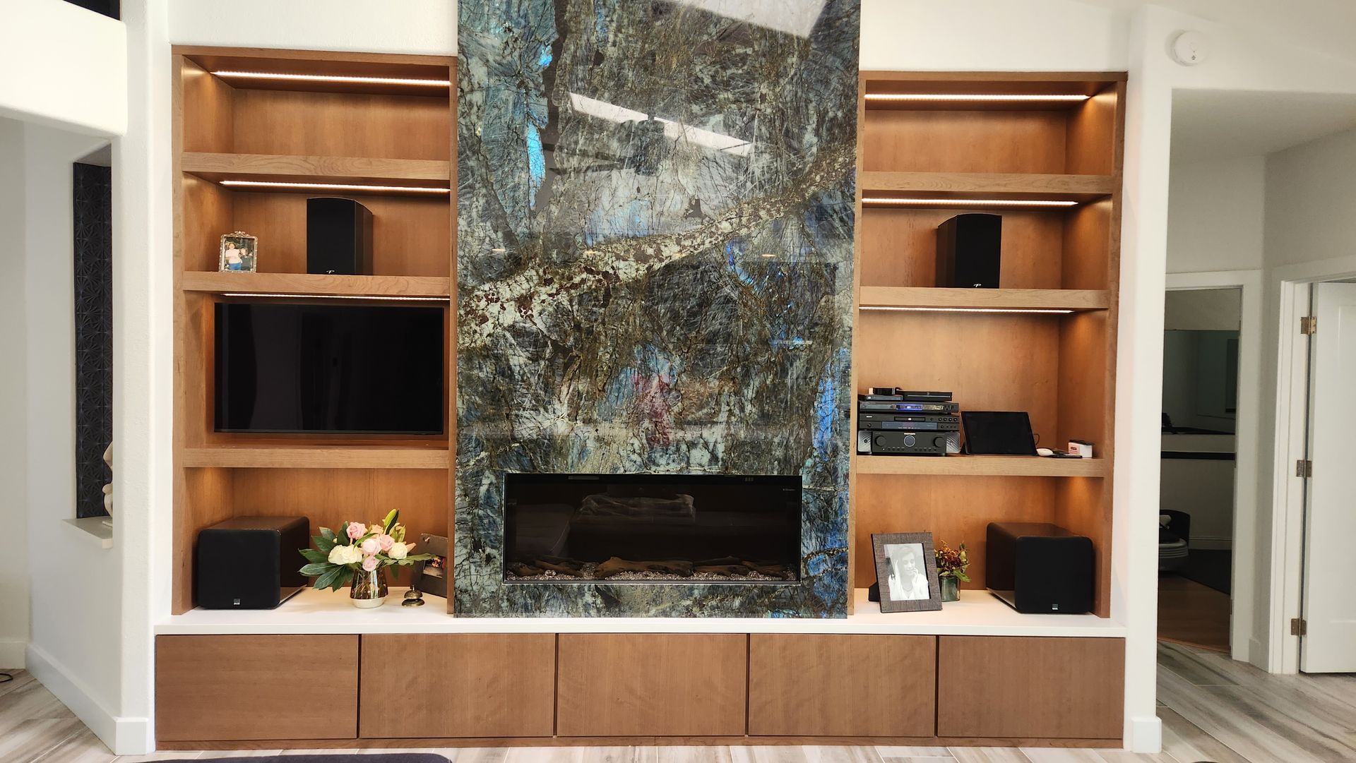 A living room with a fireplace and built in shelves