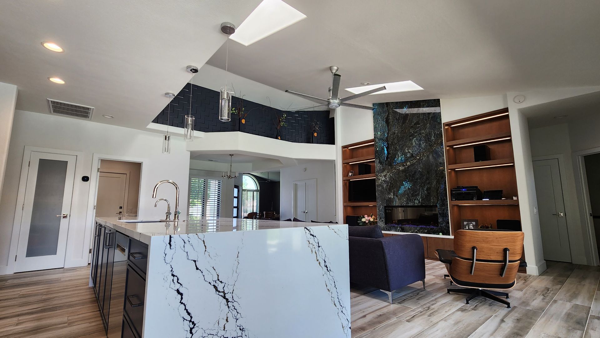 A kitchen with a large island and a ceiling fan.
