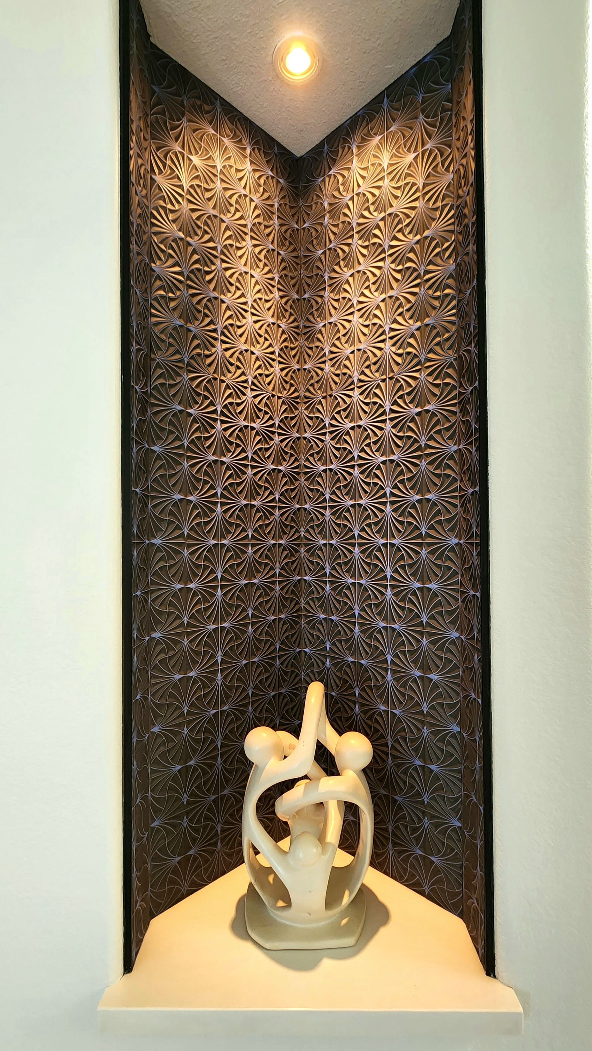 A statue of a couple standing next to each other in a niche.