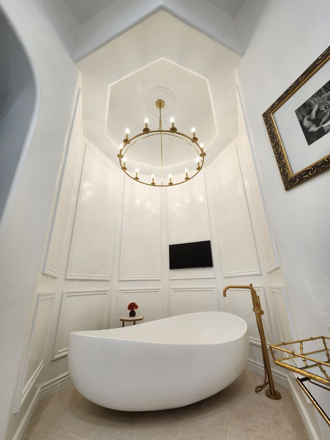 A bathroom with a bathtub and a chandelier hanging from the ceiling