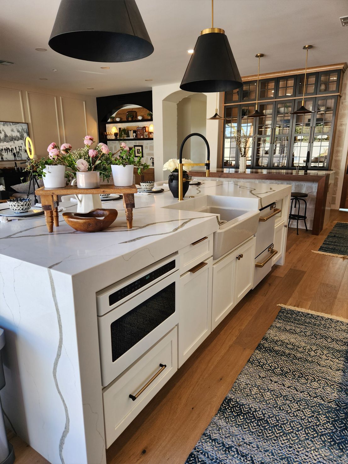 A kitchen with white cabinets, a sink, and a large island.