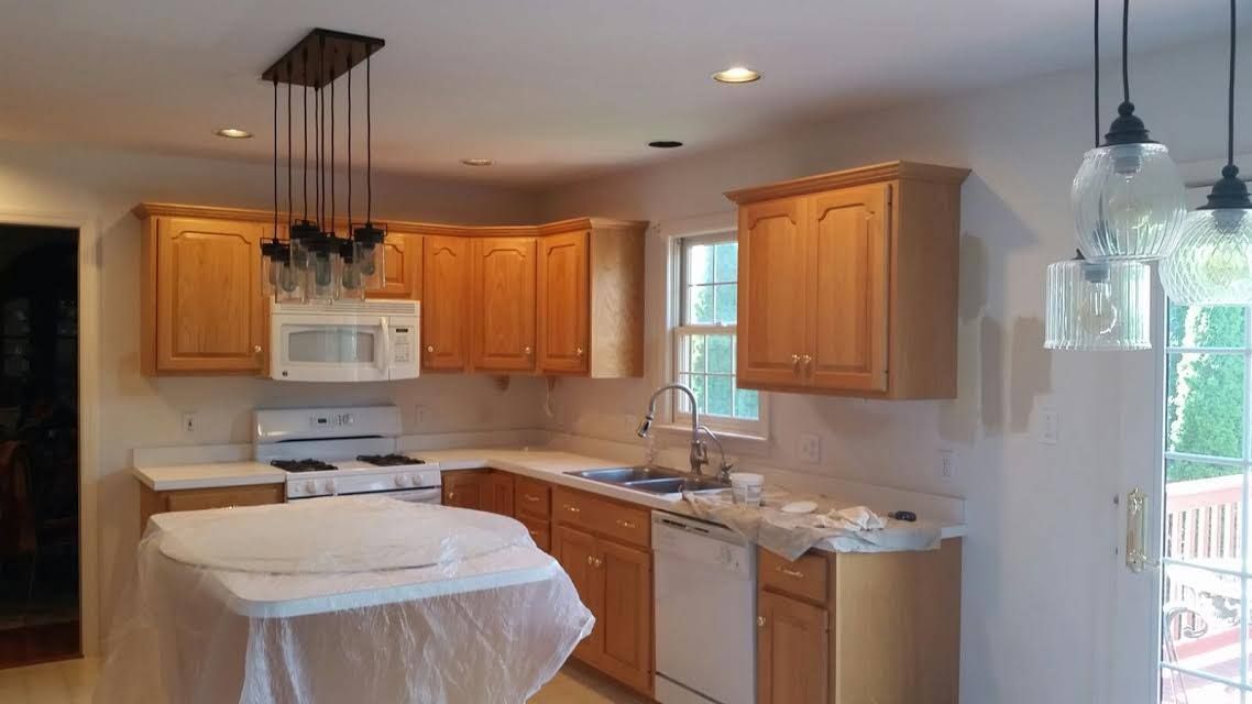 A bedroom with a bed dresser mirror and ceiling fan
