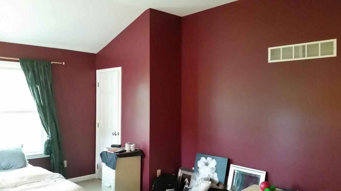 A bedroom with blue walls and a sliding glass door.