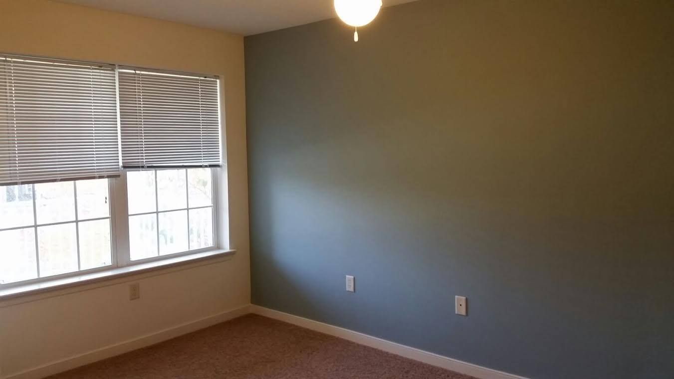 A screened in porch with a table and chairs inside