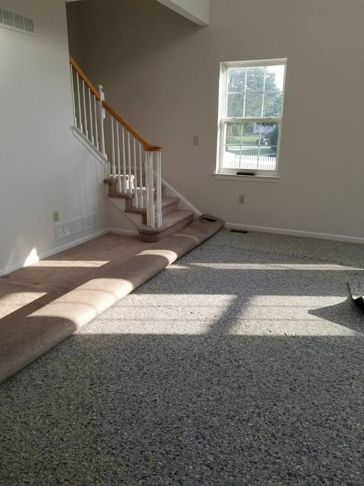 An empty living room with hardwood floors and stairs.
