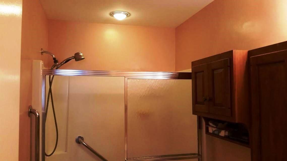A bathroom with a walk in shower and a toilet.