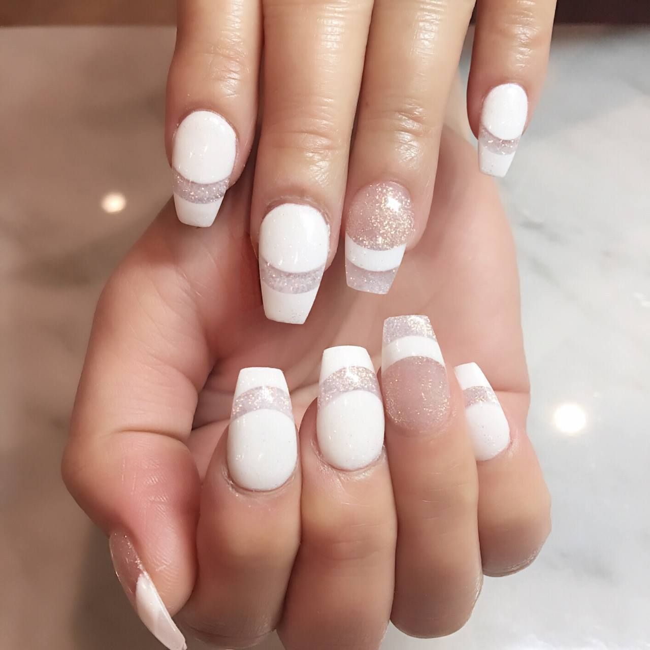 A close up of a woman 's hand with white nails
