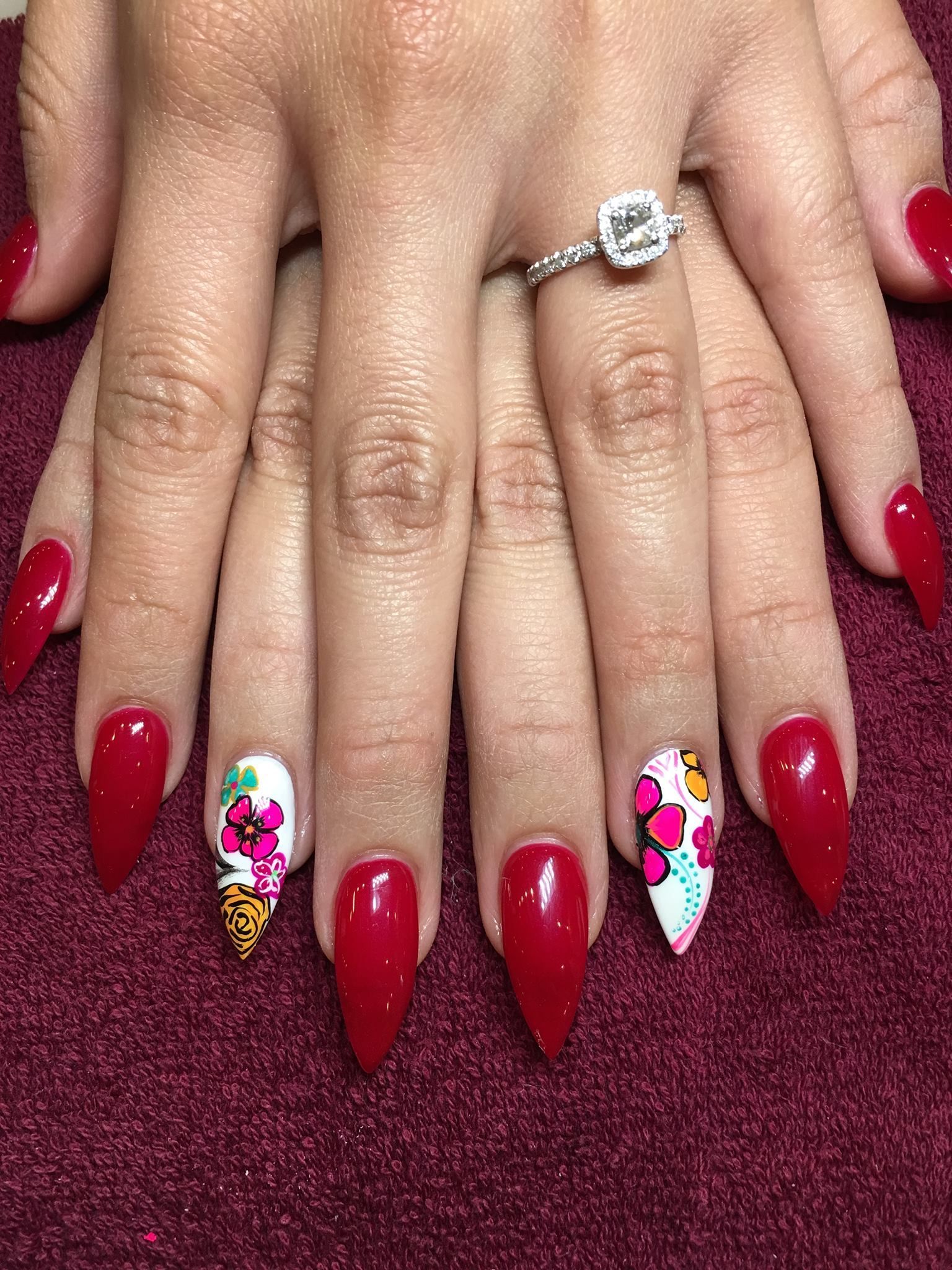 A woman 's hands with red nails and a ring on her finger.
