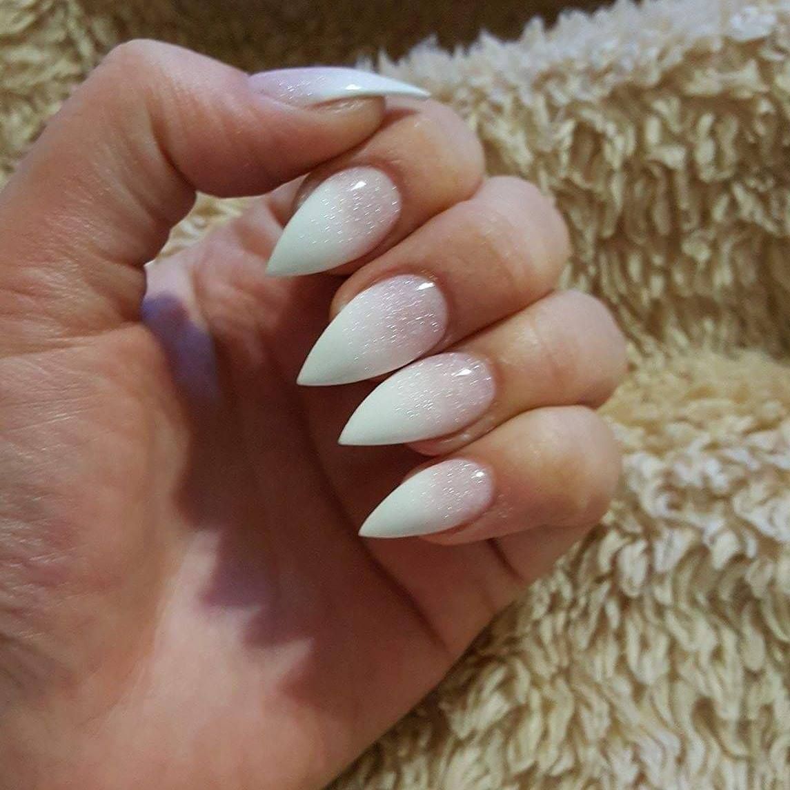 A close up of a person 's hand with long white nails