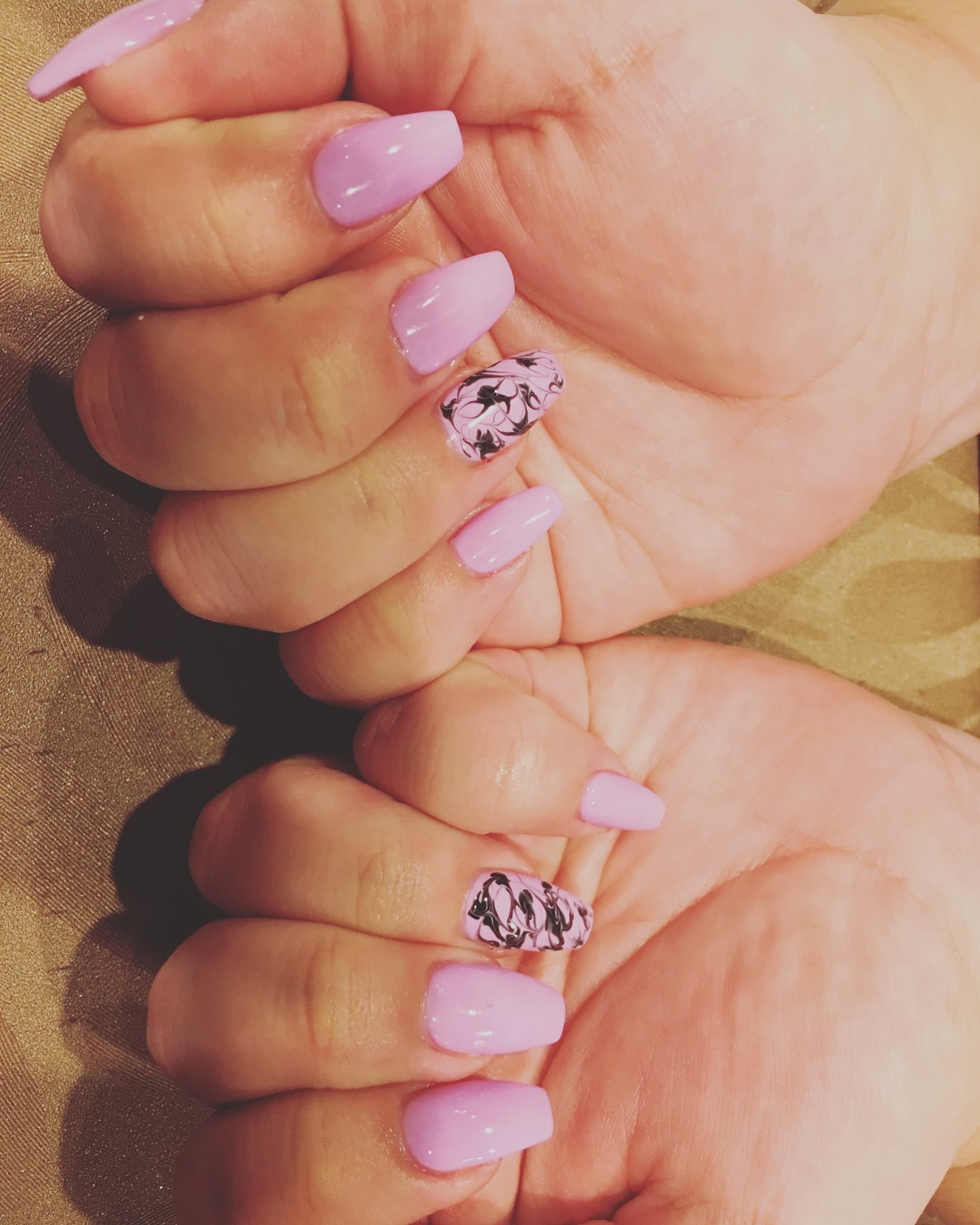 A close up of a woman 's hands with pink nails