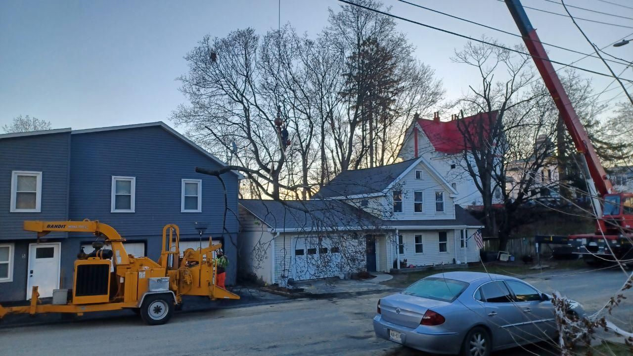 A tractor is parked in the grass in front of a house.