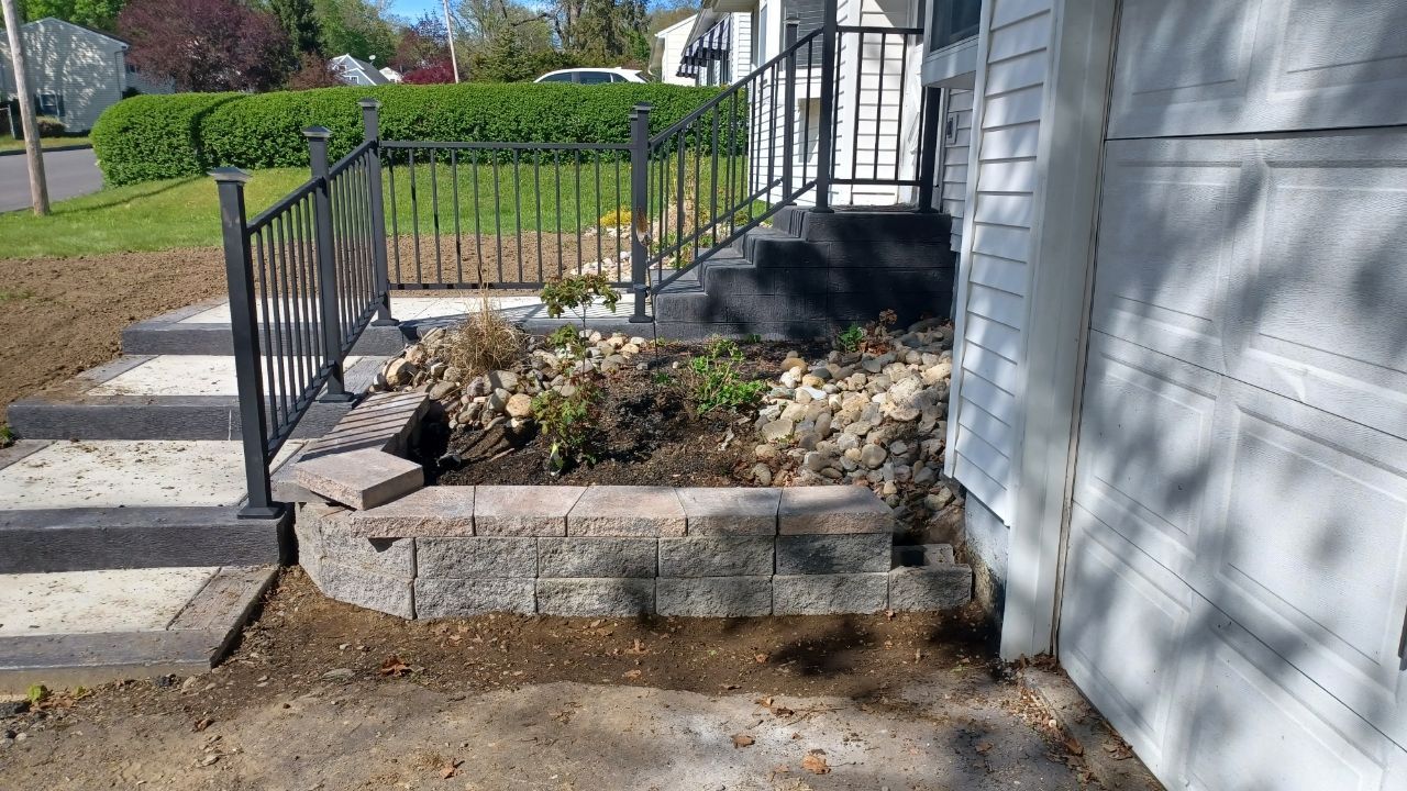 A white house with a garden in front of it.